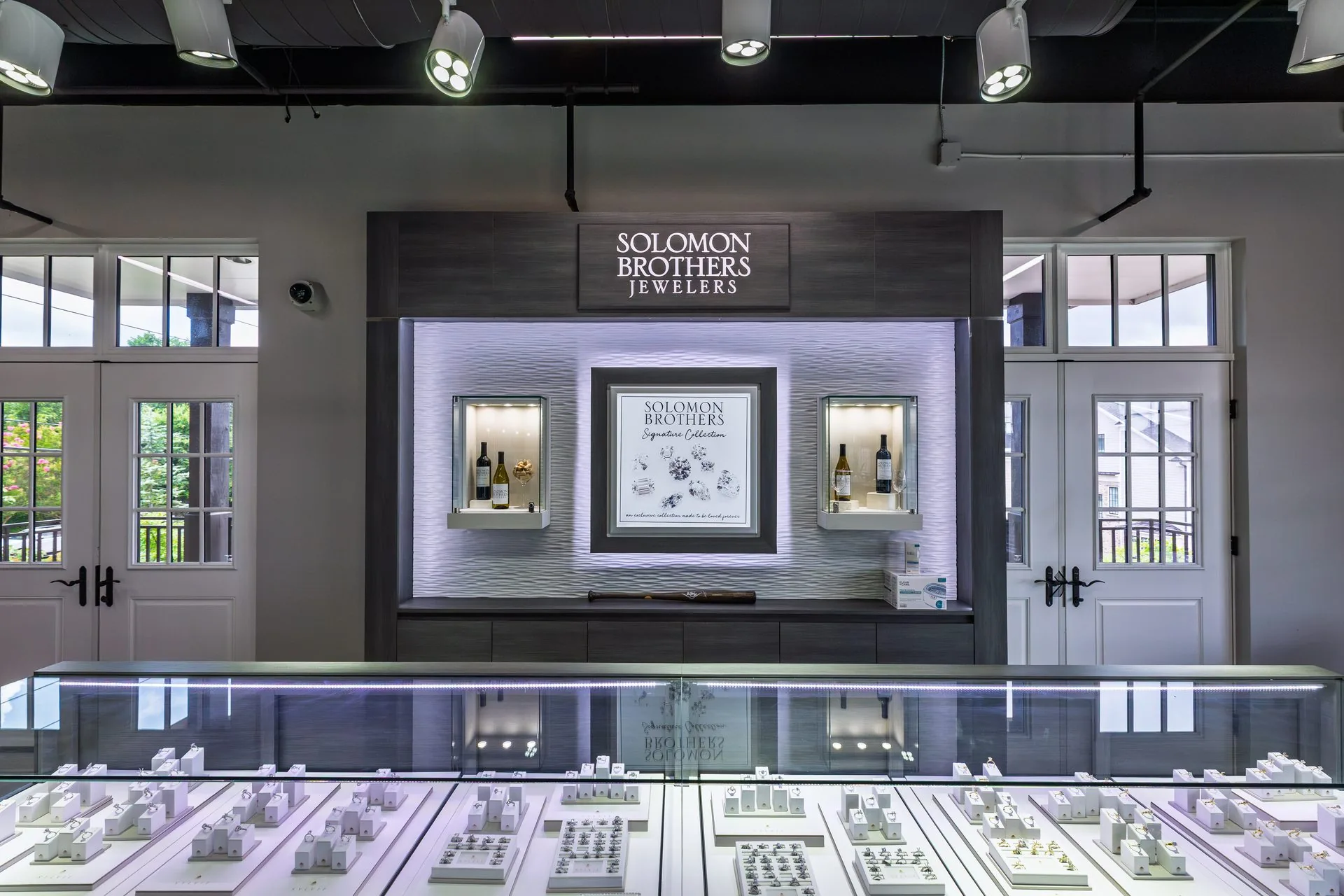 Solomon Brothers Jewelers showroom, illuminated display cases beneath the branded wall