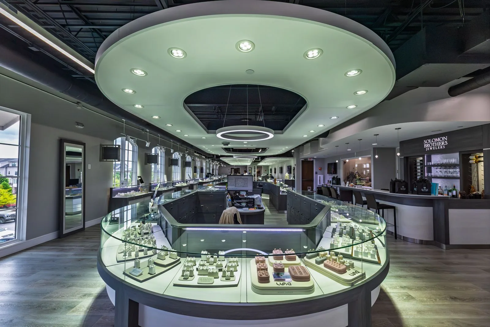 Wide view of the showroom beneath the oval ceiling light, cases glowing
